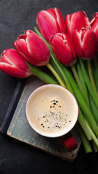 Filiżanka z kawą i tulipany na książce