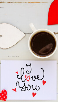 Kubek kawy obok kartki z napisem I Love You