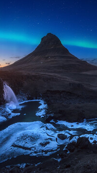 Zorza polarna nad górą Kirkjufell w Islandii