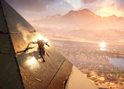Bayek na piramidzie w scenie z gry Assassins Creed: Origins