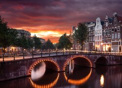 Domy i most nad Kanałem Leidsegracht w Amsterdamie o zmroku