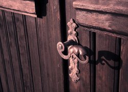 Drewniane drzwi z metalową klamką