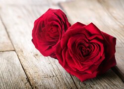 Dwie czerwone róże na deskach