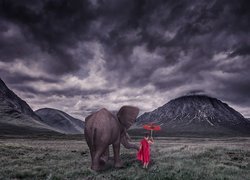 Dziecko z parasolką i słoniem w górach