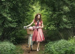 Dziewczyna z rowerem na leśnej ścieżce