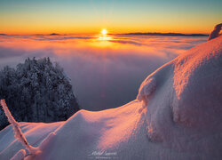 Góry zasypane śniegiem i mgła o wschodzie słońca