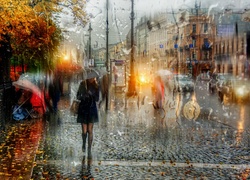 Kobieta z parasolem na deszczowej ulicy
