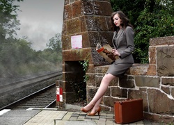 Kobieta z walizką czeka na peronie
