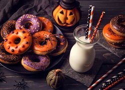 Mleko obok donutów i dekoracji na Halloween