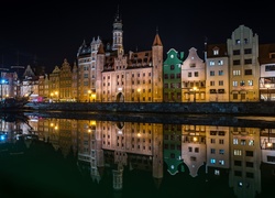 Oświetlone gdańskie kamienice odbijają się w rzece nocą