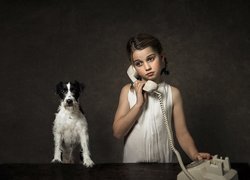 Parson Russell terrier obok dziewczynki z telefonem