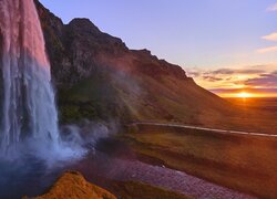 Rozświetlony blaskiem zachodzącego słońca wodospad Seljalandsfoss w Islandii