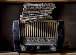 Zabytkowe radio i stare gazety przewiązane sznurkiem