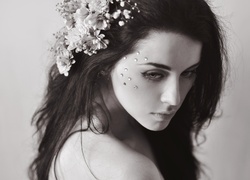 Zamyślona smutna kobieta z kwiatami we włosach