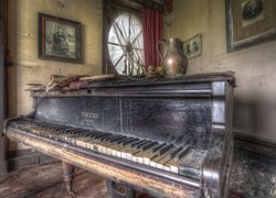 Zniszczone pianino w zaniedbanym pokoju