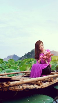 Azjatka na łodzi z kwiatami