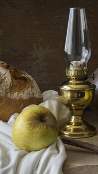 Chleb z jabłkiem obok lampy naftowej