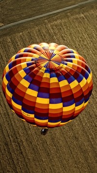 Kolorowy balon nad zaoranym polem