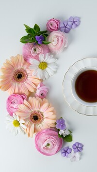 Kwiaty ułożone przy filiżance herbaty