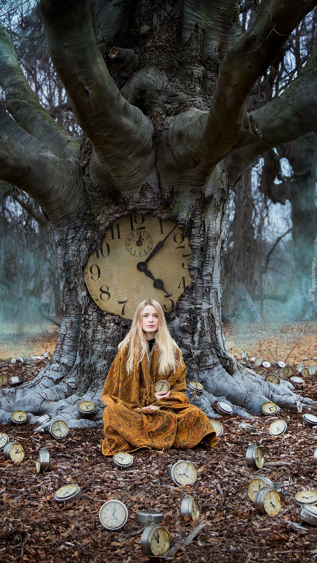 Blondynka przy drzewie z zegarem