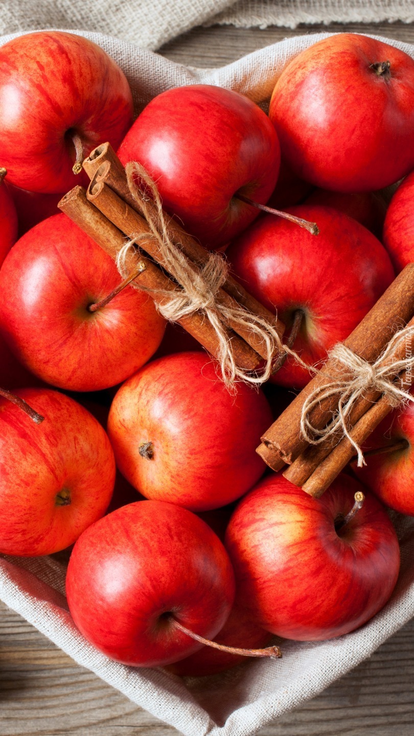 Czerwone jabłka i laski cynamonu