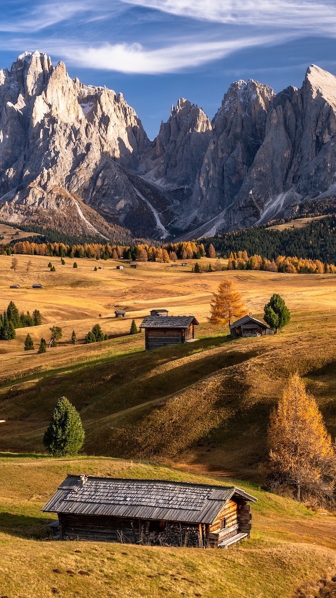 Drewniane domy w dolinie Val Gardena na tle Dolomitów