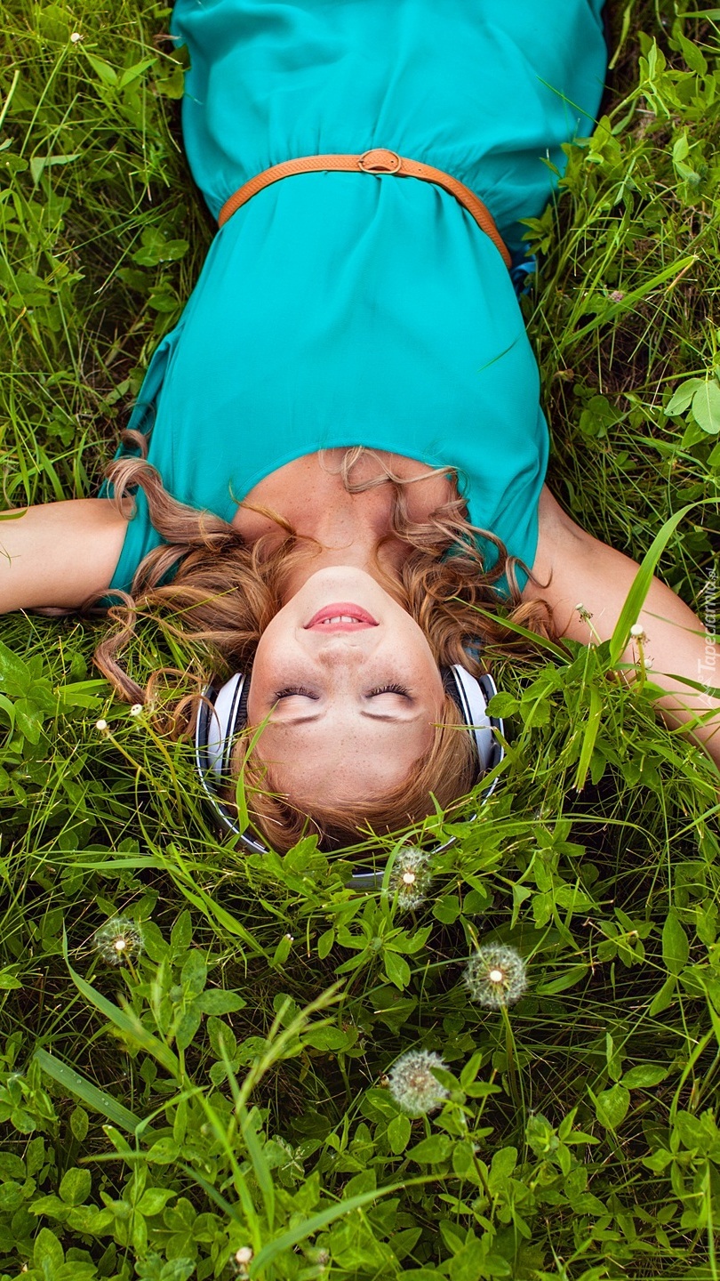 Dziewczyna ze słuchawkami na trawie