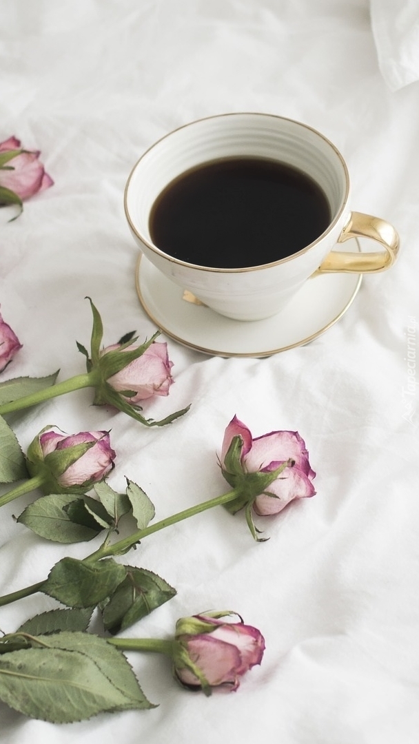 Filiżanka kawy obok róż