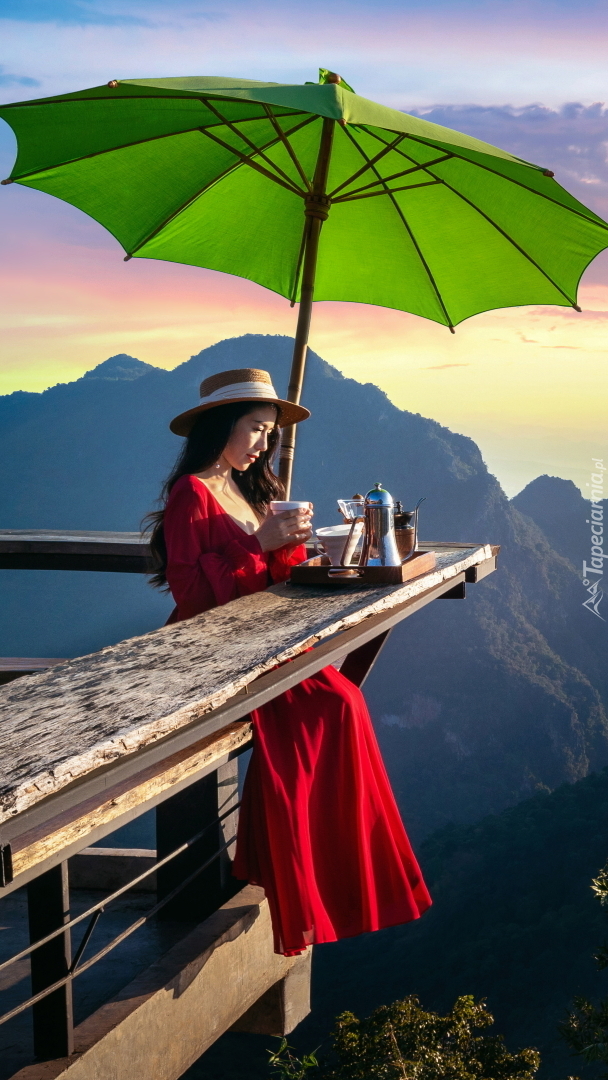 Kobieta pijąca kawę na tarasie widokowym