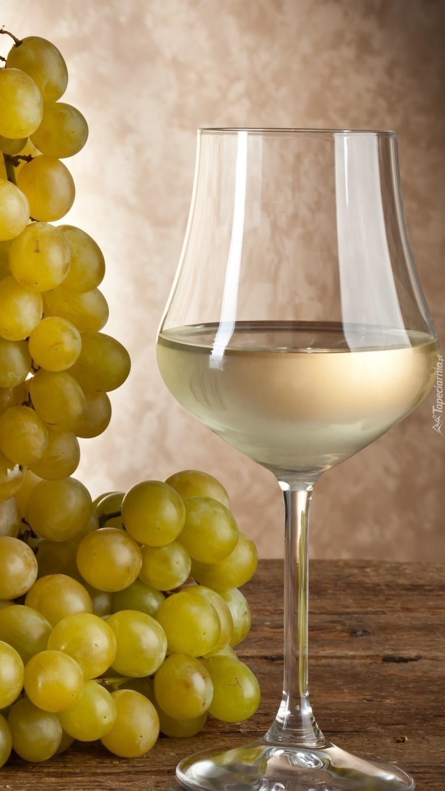Lampka białego wina obok winogron