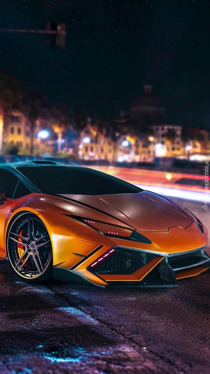 Pomarańczowe Lamborghini w mieście nocą