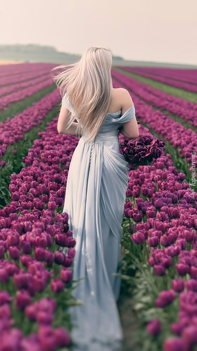 Spacer kobiety tulipanowym polem