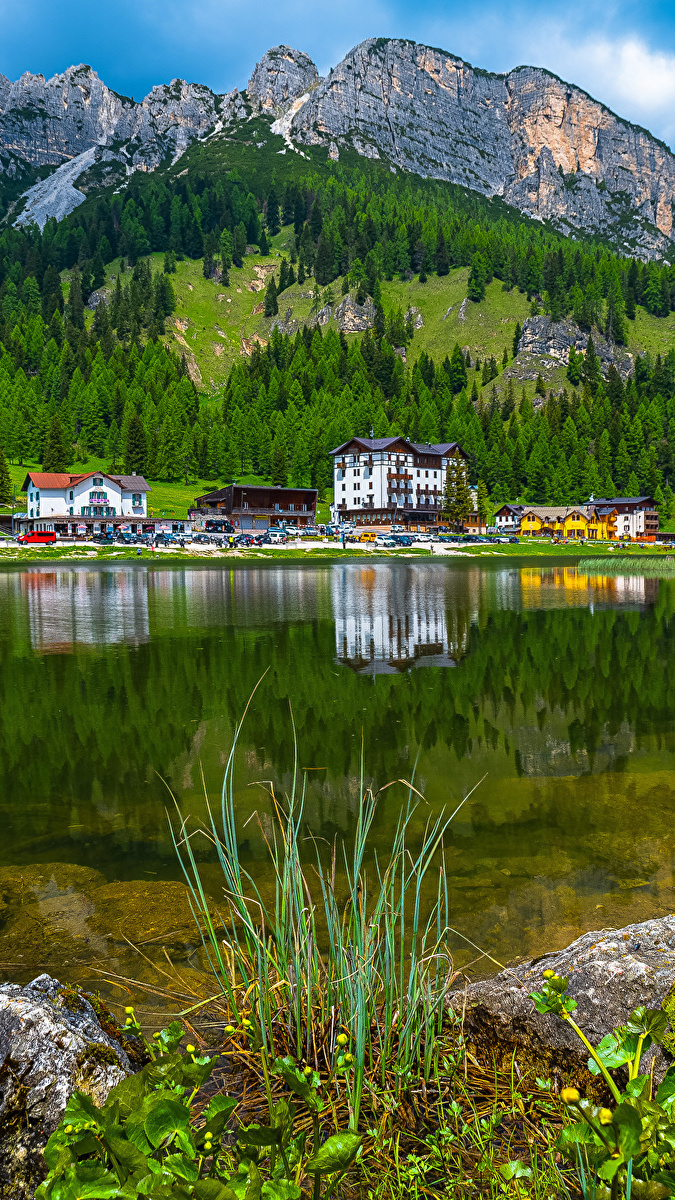 Widok znad jeziora Lago di Misurina na domy u podnóża Dolomitów