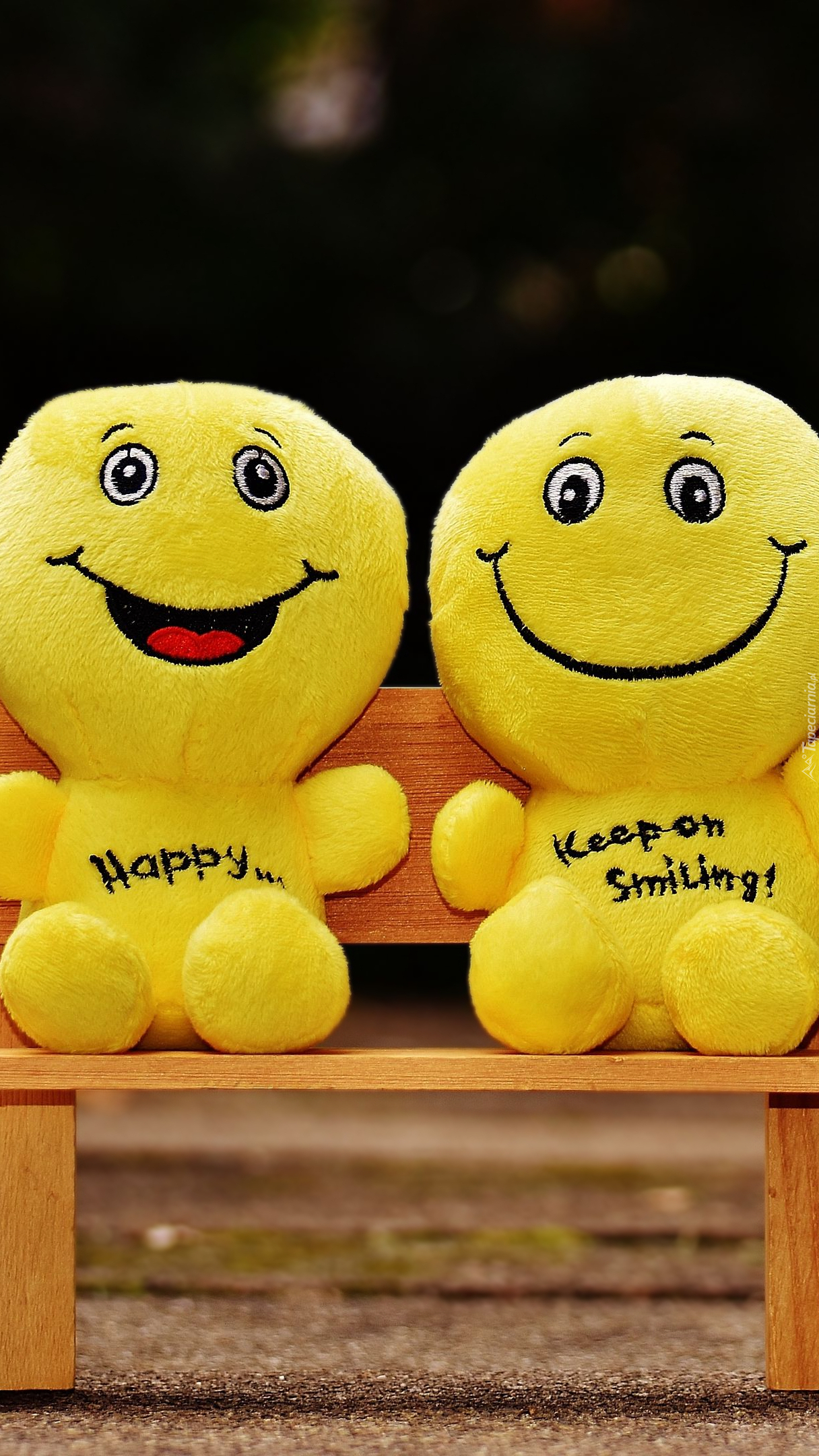 Żółte uśmiechnięte maskotki na ławeczce