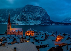 Austriacki Hallstatt z kościołem nad zimowym jeziorem w górach o zmierzchu