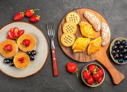 Babeczki z owocami na talerzu i ciastka na desce