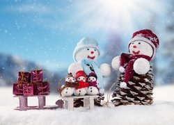 Bałwanki na śniegu z sankami i prezentami