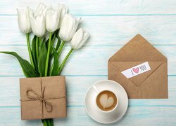 Białe tulipany obok kawy i prezentu