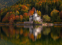 Biały dom na tle lasu nad jeziorem