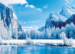 Błękitna rzeka u stóp zaśnieżonych gór i lasu