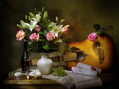 Bukiet róż i lilii w wazonie obok gitary