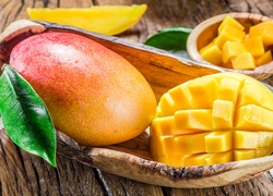 Cały owoc mango i pokrojony na kawałki w miseczkach