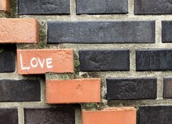 Ceglany mur z napisem love