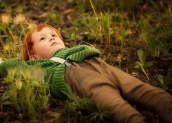 Chłopiec leżący na trawie