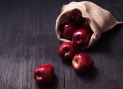 Czerwone jabłka wysypane z worka