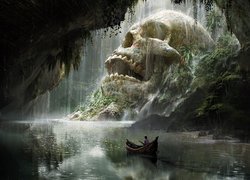 Człowiek w łódce przepływającej obok wielkiej czaszki