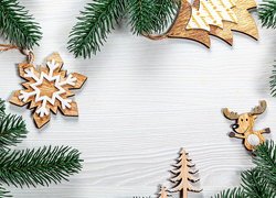 Drewniane ozdoby świąteczne obok gałązek świerku