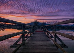 Drewniany most nad jeziorem o zachodzie słońca