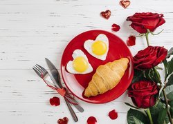 Dwa sadzone jajka w kształcie serca obok róż