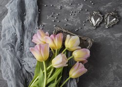 Dwa srebrne serduszka obok tulipanów na srebrnej tacy